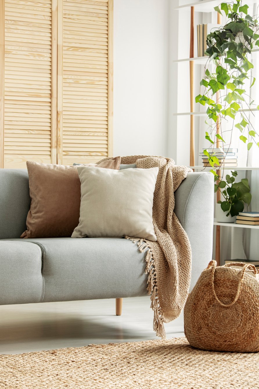 Beige cushions on gray sofa in neutral living room